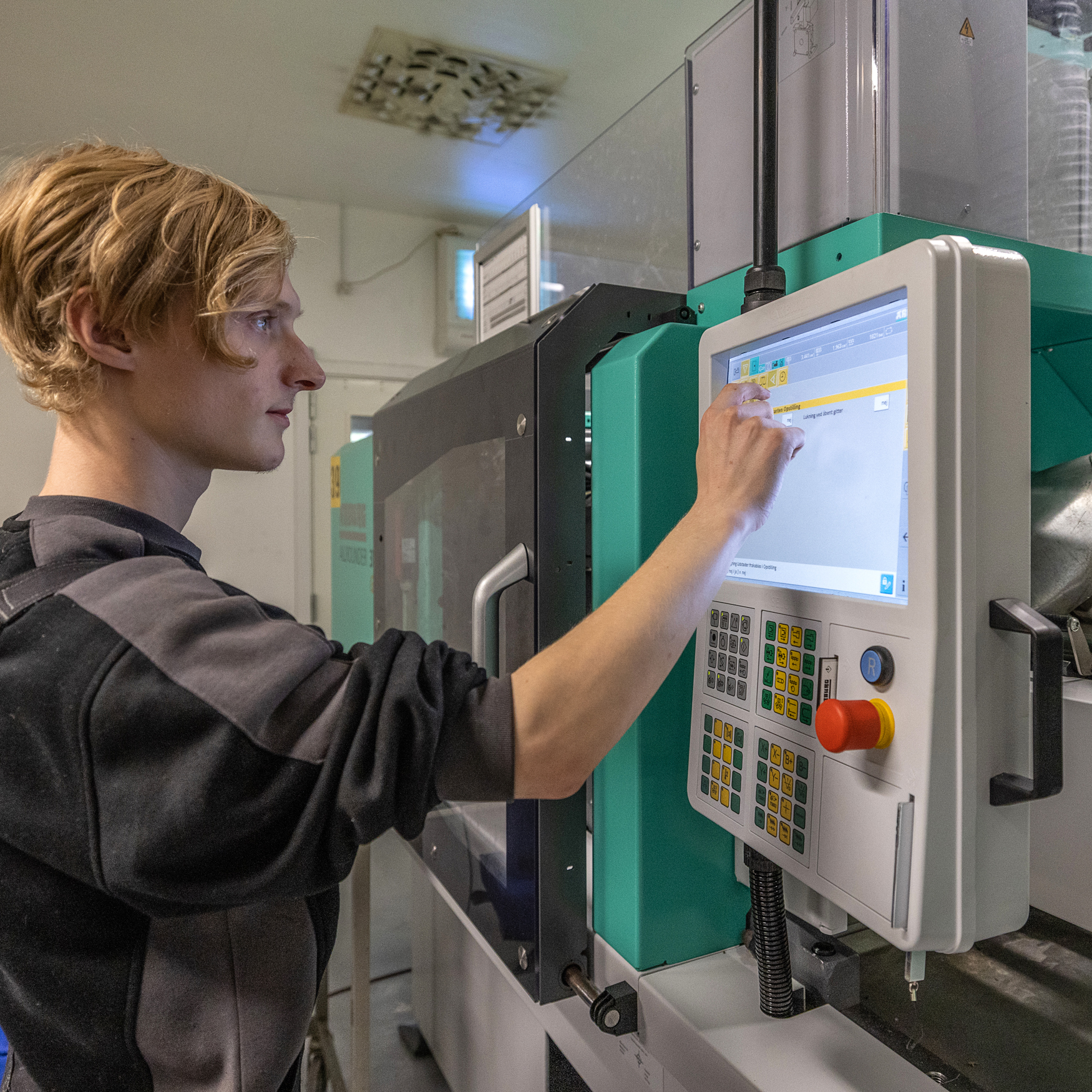 Plastmager betjener produktionsmaskine